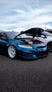 Blue Honda Civic with opened hood against the blue sky