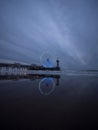 Blue hour panorama of lit illuminated sky view ferris wheel on beach pier of Scheveningen The Hague Netherlands Europe