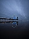 Blue hour panorama of lit illuminated sky view ferris wheel on beach pier of Scheveningen The Hague Netherlands Europe