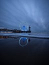 Blue hour panorama of lit illuminated sky view ferris wheel on beach pier of Scheveningen The Hague Netherlands Europe