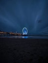 Blue hour panorama of lit illuminated sky view ferris wheel on beach pier of Scheveningen The Hague Netherlands Europe