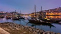 Blue hour at sunset along the river with boats and harbor barrels