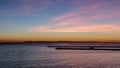 Blue hour sunset with light clouds and pink and orange hues over the Pacific Ocean in Orange County, California.