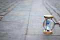 Blue hourglass and magnifying glass on stone pavement Royalty Free Stock Photo