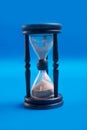 Blue hourglass over bluebackground. close up Royalty Free Stock Photo