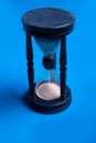 Blue hourglass over bluebackground. close up Royalty Free Stock Photo