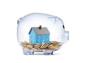 Blue house on money inside transparent piggy bank Royalty Free Stock Photo