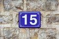 Blue house number fifteen on a stone wall background Royalty Free Stock Photo