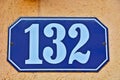 A blue house number plaque, showing the number one hundred thirty and two Royalty Free Stock Photo