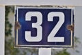 A blue house number plaque, showing the number thirty two Royalty Free Stock Photo