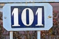 A blue house number plaque, showing the number one hundred and one Royalty Free Stock Photo