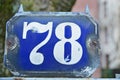 A blue house number plaque, showing the number seventy eight Royalty Free Stock Photo