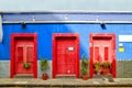 Blue house with three red doors in the old Town of San Cristobal de La Laguna. Royalty Free Stock Photo