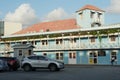 Blue house in typical bright colors and colonial style decorated by red flowers on the Caribbean island of Barbados in Bridgetown.