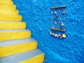 Blue house wall with yellow staircases, Greece