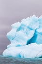 A blue ice berg floating in the Arctic north of Svalbard in the Arctic