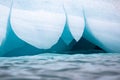 A blue ice berg floating in the Arctic north of Svalbard in the Arctic