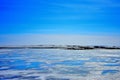 Blue ice and cracks on the surface of the ice. Frozen lake under a blue sky in the winter. Royalty Free Stock Photo