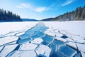 Blue ice and cracks on the surface of the ice. Frozen lake under a blue sky in the winter. The hills of pines. Winter Royalty Free Stock Photo