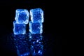 Blue ice cubes reflection on black table background Royalty Free Stock Photo