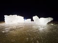 Blue ice cubes shine on flat glacier surface. Thanks to spot light shine details