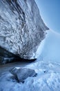 Blue ice wall of cave arch at winter mountains Royalty Free Stock Photo