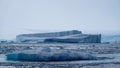 Blue icebergs floating in the ocean.