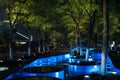 Blue illuminated water feature in the park at night