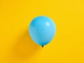 Blue inflated balloon on yellow background Royalty Free Stock Photo