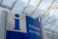 Blue info sign at the arrivals in English and German at the airport Royalty Free Stock Photo