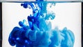 Blue ink dropping and dissolving in clear water creating abstract fluid motion patterns in glass container Royalty Free Stock Photo