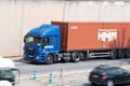 Iveco Stralis truck loading a red container trailer along Barcelona's Ronda Litoral