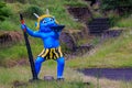 Blue Japanese oni demon in front of dry stone riverbed