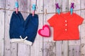 Blue jeans for a baby boy, a red shirt and a toy red heart on a clothesline Royalty Free Stock Photo