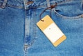 Blue jeans with a blank paper price tag. Royalty Free Stock Photo