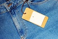 Blue jeans with a blank paper price tag. Royalty Free Stock Photo