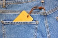 Blue jeans with a blank paper price tag. Royalty Free Stock Photo