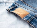 Blue jeans with a brown leather blank label, close-up. Jeans texture. Fashion denim background for sewing, copy space. Label on Royalty Free Stock Photo