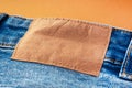 Blue jeans with a brown leather blank label, close-up. Jeans texture. Fashion denim background for sewing, copy space. Label on Royalty Free Stock Photo