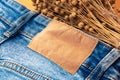 Blue jeans with a brown leather blank label and dry linen, close-up. Jeans texture. Fashion denim background for sewing, copy Royalty Free Stock Photo