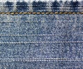 Blue jeans cloth stitching with orange thread.