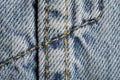 Blue jeans fabric macro seam pattern blurred background. Denim background texture for design. Royalty Free Stock Photo