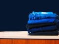 Blue jeans isolated on blue background. Jeans stacked on a light background. Jeans background. Stack of clothing  close up. Royalty Free Stock Photo