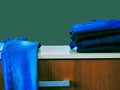 Blue jeans isolated on green background. Jeans stacked on a light background. Jeans background. Stack of clothing  close up. Royalty Free Stock Photo