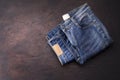 Blue jeans laying on a dark wooden table. Modern fashion jeans - top view with space to copy text Royalty Free Stock Photo