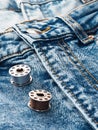 Blue jeans, metal spools of thread, close-up. Tailoring of casual denim clothing concept. Cutting and sewing, background. Natural