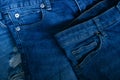 Blue jeans pants clothes pile background. Stack of blue jeans on shop desk,Denim jeans background. Destroyed torn classic denim Royalty Free Stock Photo