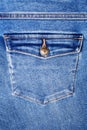 Blue jeans pocket with flap and brass metal button close up, jeans pocket background, blue denim backdrop, jeans pocket pattern Royalty Free Stock Photo