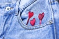 Blue jeans and red hearts from pocket on black background top view flat lay. Detail of nice blue jeans. Jeans texture or denim Royalty Free Stock Photo