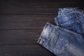 Blue jeans resting on a dark black wooden table. Modern fashion jeans - top view with space to copy text Royalty Free Stock Photo